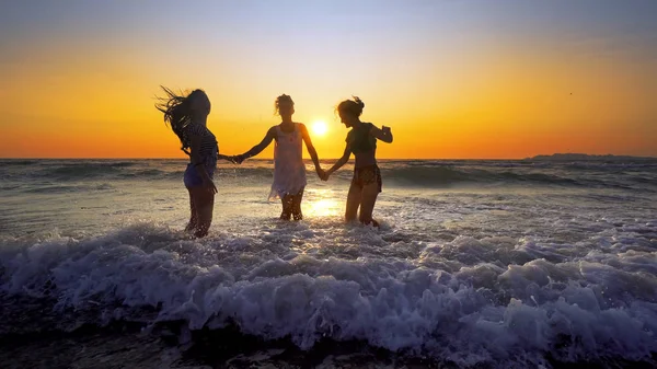 Группа Счастливых Девушек Развлекающихся Морских Волнах Пляже Фоне Заката — стоковое фото