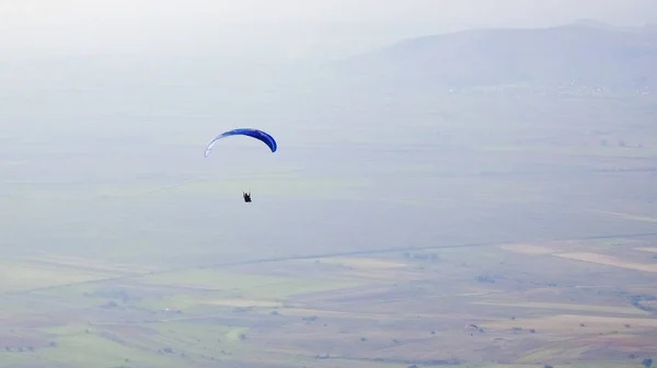 从山谷上空飞过的滑翔伞观 — 图库照片