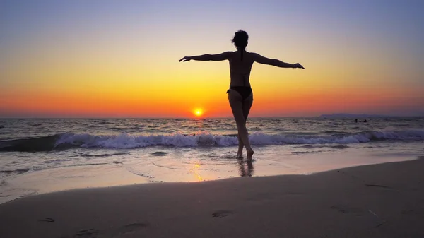 日没の背景 自由の概念にワイド オープンの手で海を歩く婦人 — ストック写真