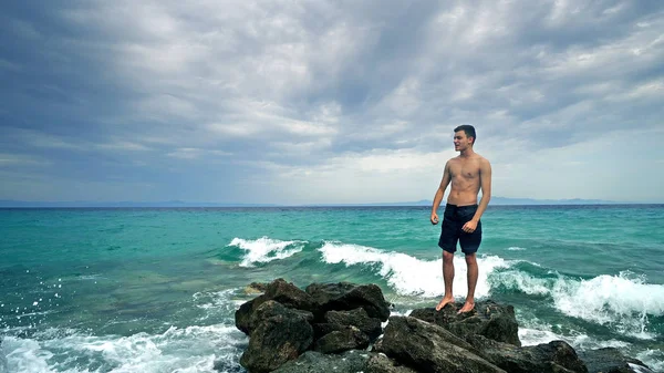 Fitness Atleta Masculino Forma Pie Sobre Rocas Marinas Mostrando Sus — Foto de Stock