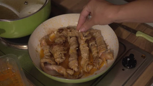 ガスコンロでフライパンで揚げる鶏の串焼き女性調理 — ストック写真