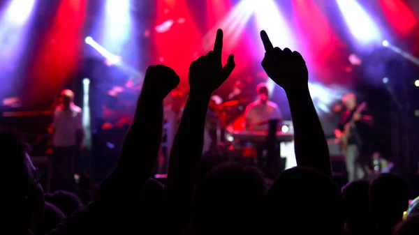 Konserin siluetleri parlak sahne ışıkları önünde kalabalık. Kamu konser, Bilet yok olay