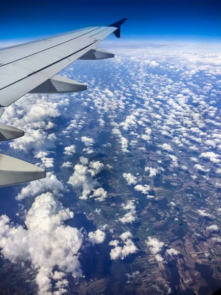 垂直雲上空を飛んでいる飛行機の翼 — ストック写真