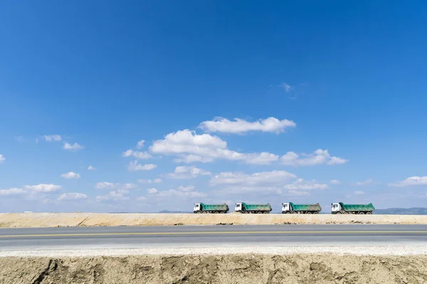 Bouwplaats Weg Met Vier Vrachtwagens Tegen Blauwe Hemel — Stockfoto