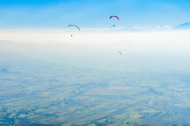 Mavi gökyüzü arka plan üzerinde uçan paraşütler 