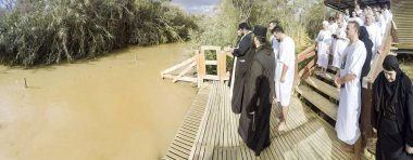 YERICHO, ISRAEL - 20 Şubat 2017: Kuzey İsrail 'deki Ürdün Nehri' nde yapılan toplu vaftiz töreninde Hristiyan hacılar. Hristiyan geleneğine göre İsa Ürdün Nehri 'nde Vaftizci Yahya tarafından vaftiz edildi.