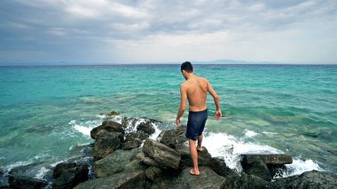 Bulutlu gökyüzü arka plan iskelede duran genç adam