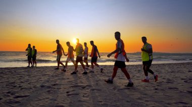 Durres, Arnavutluk - Ağustos, 2017 yaklaşık: futbol spor takımı yapan eğitim deniz günbatımı sırasında koşu