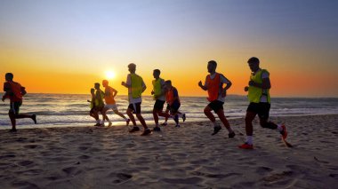Durres, Arnavutluk - Ağustos, 2017 yaklaşık: futbol spor takımı yapan eğitim deniz günbatımı sırasında koşu