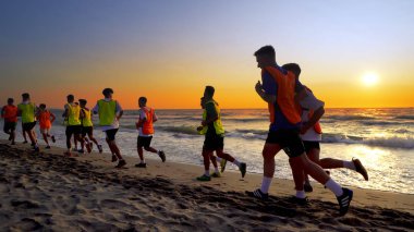 Durres, Arnavutluk - Ağustos, 2017 yaklaşık: futbol spor takımı yapan eğitim deniz günbatımı sırasında koşu