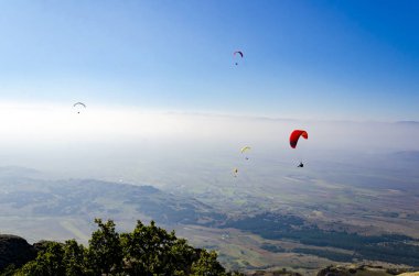 Mavi gökyüzü arka plan üzerinde uçan paraşütler 