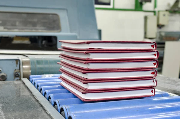 Book, magazine, production line into press plant house. Automatic assembly line, selective focus and copyspace