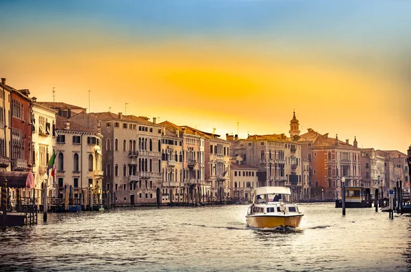 grand channel with boat and color architecture in Venice, Italy during sunset