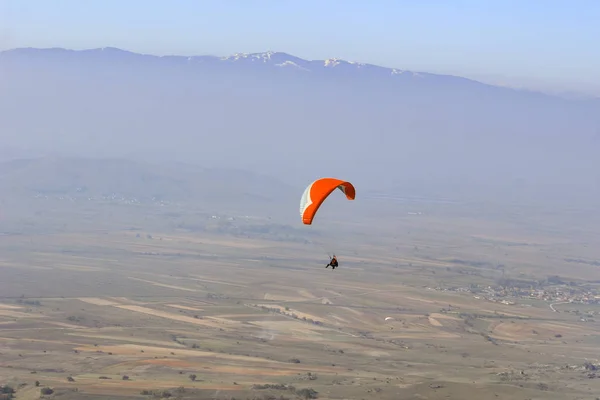 从山谷上空飞过的滑翔伞观 — 图库照片
