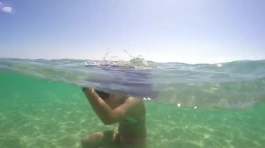 Kız suyun altından gideriz ve sarmal sıçramasına bir saç yapmak, gopro kubbe yarım sualtı görünümü, ağır çekim