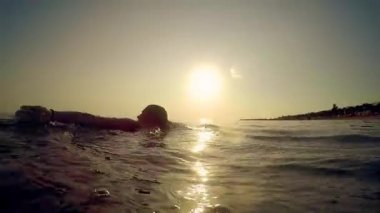 Mutlu kız yüzme ve deniz günbatımı üzerinde sıçramasına