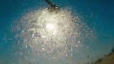 Güneş ve lens ile güzel mavi gökyüzü arka plan üzerinde ağır çekimde tatlı su ile duş açık plaj flare efektleri