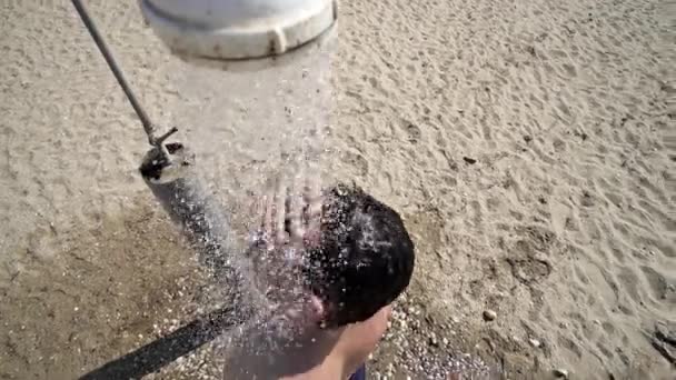 Junger Mann Wäscht Haare Unter Der Stranddusche — Stockvideo