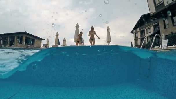 つの女の子を実行一緒に ジャンプにプール Gopro ドーム半水中ビュー スローモーション — ストック動画