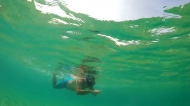 Deniz suyu yüzeyinde yüzen şnorkel maskeli adam hazine arıyor, gopro yarı sualtı manzarası
