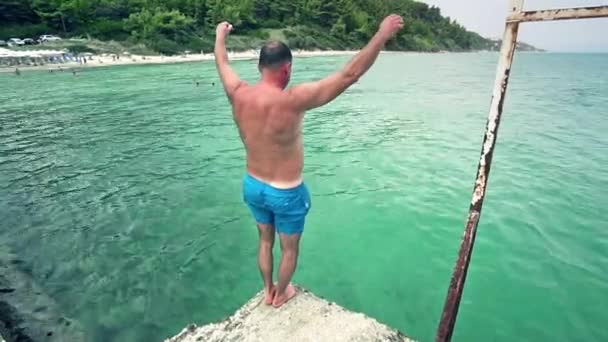 Mann Springt Von Seebrücke Ins Meer — Stockvideo