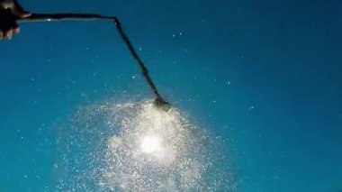Yaz duş başlığı. Bir close-up bir duş kafa su sprey mavi gökyüzünün altında. Ağır çekim