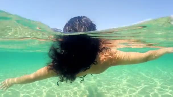 Брюнетка Кудрявая Женщина Плавает Спокойной Поверхности Воды Водой Сексуальном Купальнике — стоковое видео
