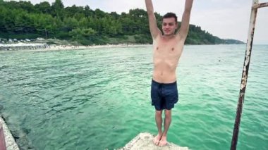 Deniz turkuaz suyu, ağır çekim flip geri çocuk atlama spor yapar