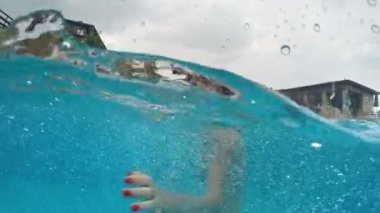 Yağmur kameraya gülümseyen yüzme havuzunda mutlu teen yağmur