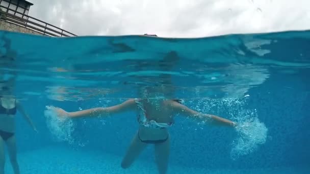 Joven Hembra Una Piscina Divirtiéndose Bajo Agua Agitando Mano Cámara — Vídeos de Stock