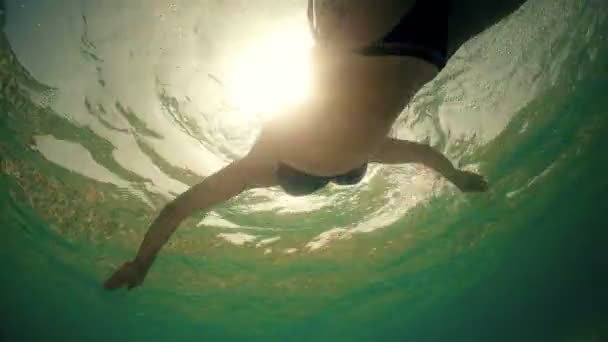 跟随一名女子在游泳池里游泳 水下可以看到日落的阳光和镜头耀斑 — 图库视频影像