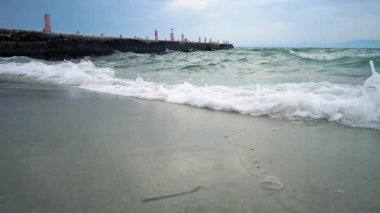 Doğa arka plan, Deniz dalgaları arka planda iskele görünümü ile plaj kum sıçrayan, Yavaş Hareket