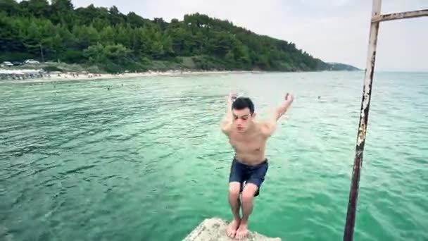 少年ジャンプのスポーツになります後ろ宙返り海の青緑色の水 — ストック動画