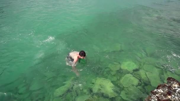 ターコイズ ブルーの海の水 スローモーション スローモーションで泳いでいる幸せな少年 — ストック動画