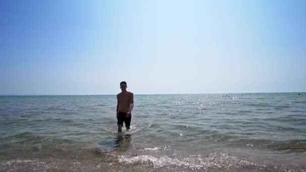 海のビーチで水から歩いてハンサムなアスリート男性 映画のような定常ショット — ストック動画