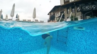 Genç arkadaşlar metal merdiven merdivenlerde çıkıyor bir yüzme havuzunda, gopro kubbe yarım sualtı görünümü, ağır çekim