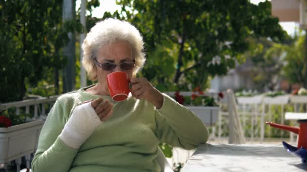 Anziana Donna Anziana Con Mano Ferita Bere Caffè Seduta All — Video Stock