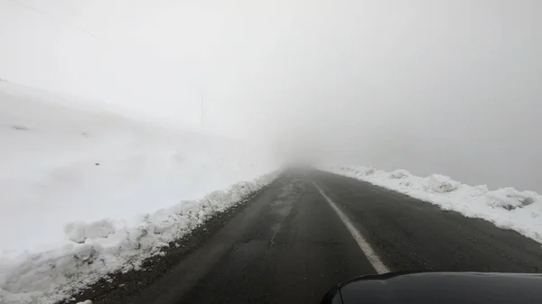 在一场暴雪中 汽车在冬路上行驶 — 图库照片