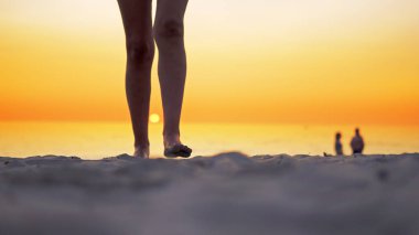 Genç Latin Amerikalı kız okyanus plaj tarafından günbatımında yürüyüş çıplak bacaklar ayak