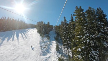 Kış resort, Pov shot teleferik draging aracılığıyla bir çam ormanı bölgede gündoğumu dağ kayak tesisi