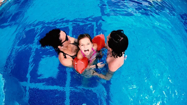 家庭母亲和女儿在豪华泳池中玩耍的鸟图 Thay 坚持舌头出来 使有趣的脸微笑 慢动作 — 图库照片