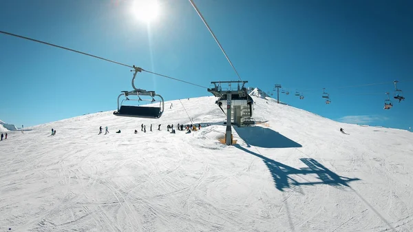 滑雪缆车与座位在山上与人民滑雪和滑雪板在斜坡上的看法 — 图库照片