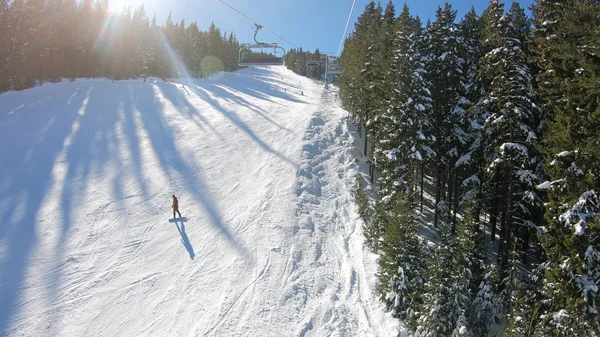 斜面と遠くの雪のスキーヤーの空中写真とスキー場のリフトからハメ撮りに山頂が覆われています — ストック写真