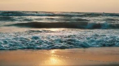 Gün batımında sahilde dalgalar