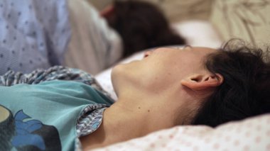 Uyku zamanı eğlenceli. Genç gülümseyen genç uykulu kız kardeşi alay yatakta eğleniyor