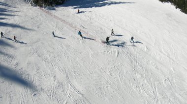 Kayak merkezi, yamaç, kayak asansöründeki insanlar, yüksek irtifadaki dağ zirvesindeki kayakçılar.