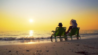 Mutlu aile anne ve oğlu şapka ile yaz tatili sahilde lüks günbatımı keyfini çıkarın. Seyahat kavramı