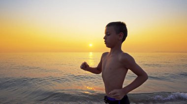 Koşma, günbatımı karşı deniz sahilde koşu genç çocuk closeup