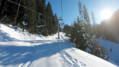 Güneşli bir günde Bulgaristan 'ın Bansko kentindeki Todorka Dünya Kupası kayak merkezinde dağlarda kayak pistleri ve kayak asansörleri olan manzara pov' u.