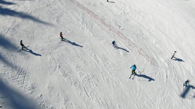 Kayakçılar ve snowboard kayak yamacı bakırlı Dağ Zirvesi kış tatil üzerinde üzerinde bir güneşli havanın tadını havadan görünümü